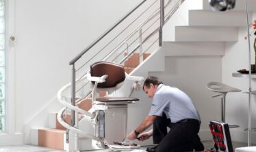 Un ingeniero de Stannah quita una silla salvaescaleras curva de una escalera.